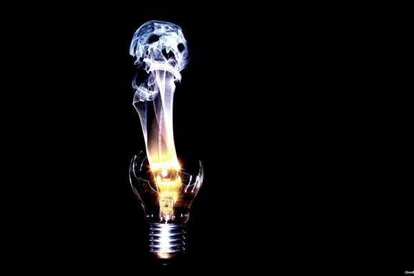 A broken light bulb on a black background with fire