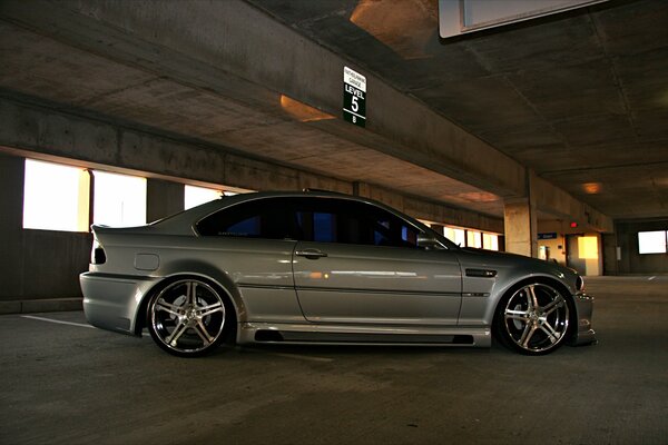 BMW plateado con grandes discos en el estacionamiento