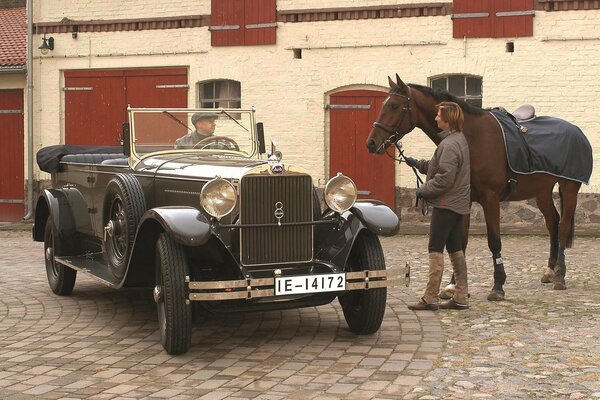 Retro audi car of 1929 year of release next to the horse