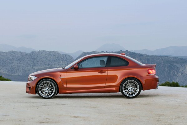 Orange BMW car on the background of mountains