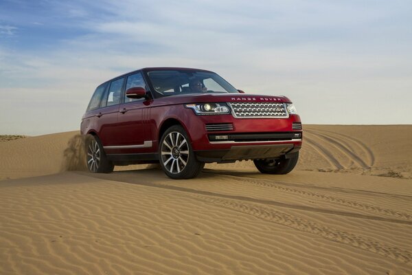 A jeep is driving through the desert. Sand, dunes - beautiful view