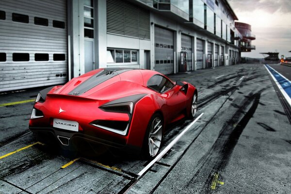 Voiture de sport rouge près du bâtiment