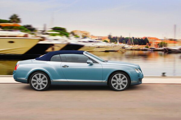 El coche continental azul de bentley conduce adelante