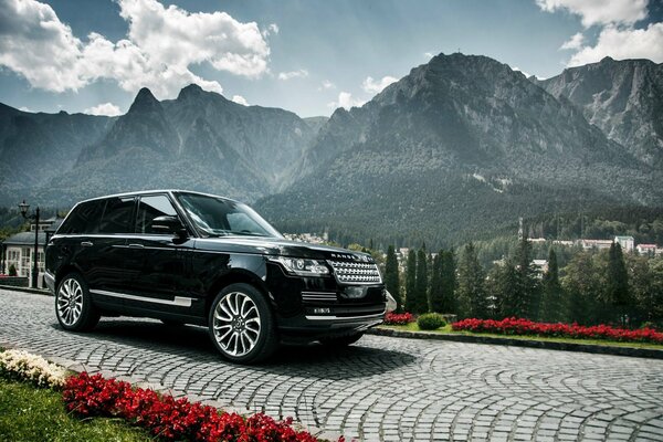 Range rover di colore nero nel paesaggio delle montagne