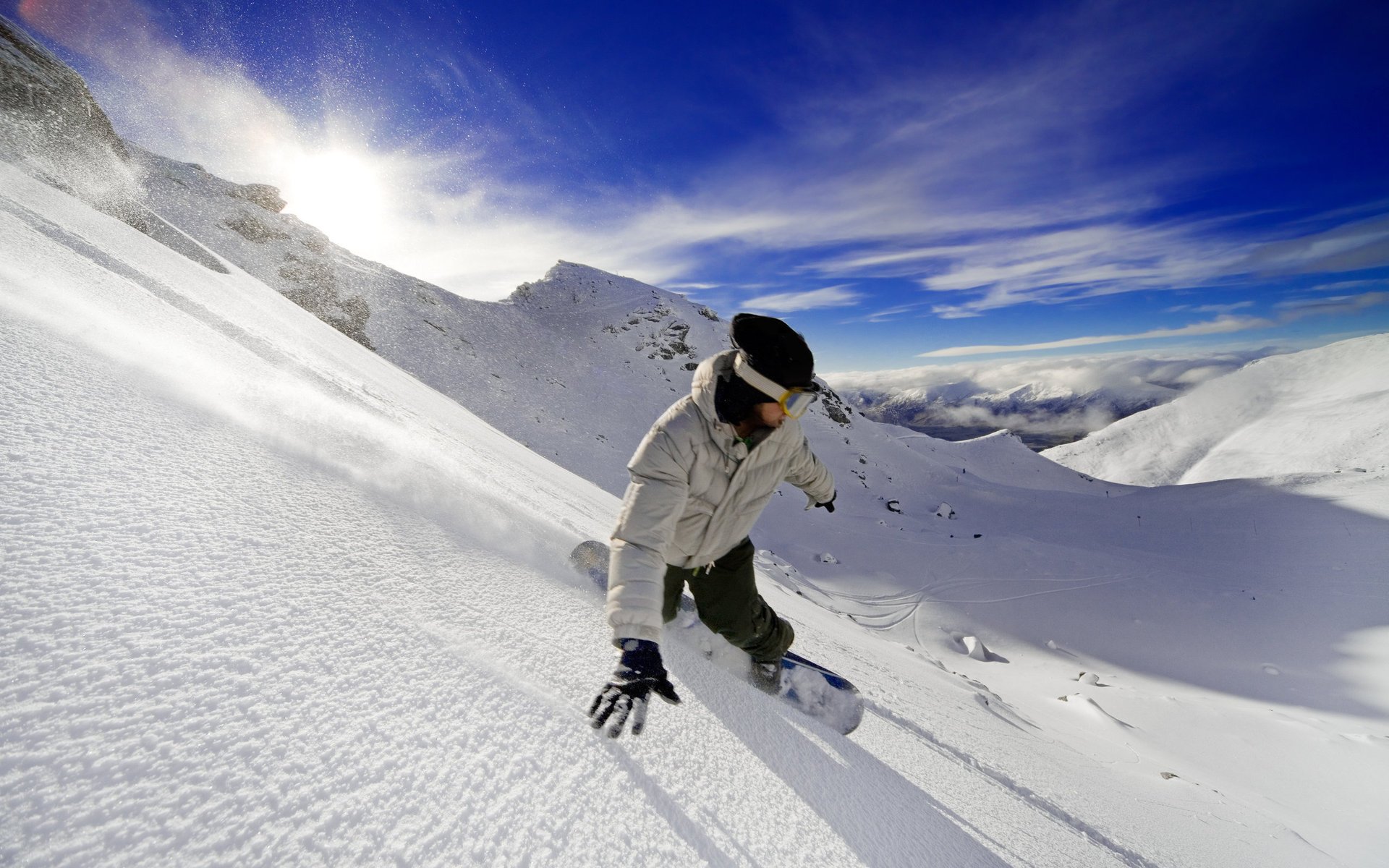 snowboard adrenalina wolność góry śnieg zaspy sport ekstremalne zima niebo zejście facet słońce chmury wysokość