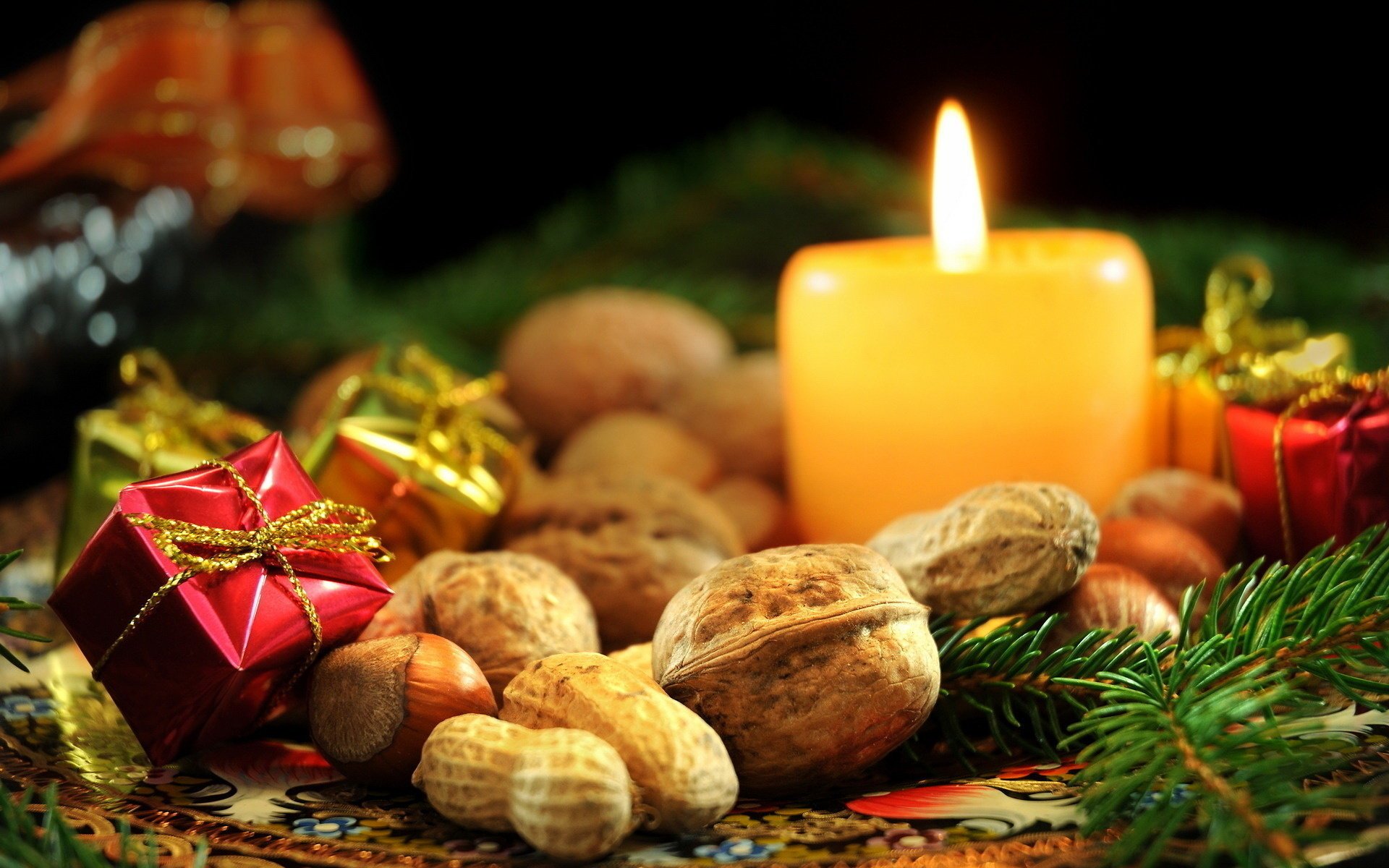 cashews new year focus holiday candle nuts gifts hazelnuts walnuts needles branch spruce fire macro decoration flame