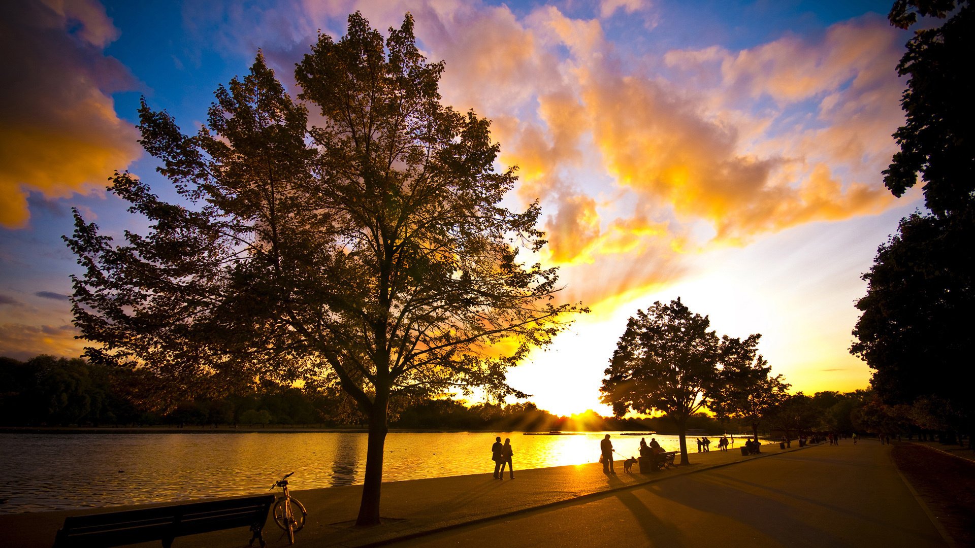 rosso ble tramonto alberi fiumi cielo natura lungomare persone città sera passanti relax negozi piazza fiume superficie liscia nuvole