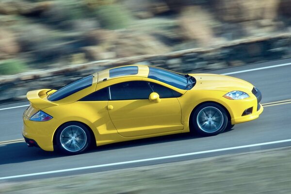 A bright yellow car is flying in traffic on the highway