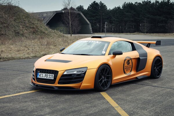 Voiture de course orange vif se dresse sur la route