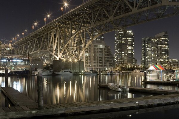 Puente sobre el río nocturno. Luces de la ciudad