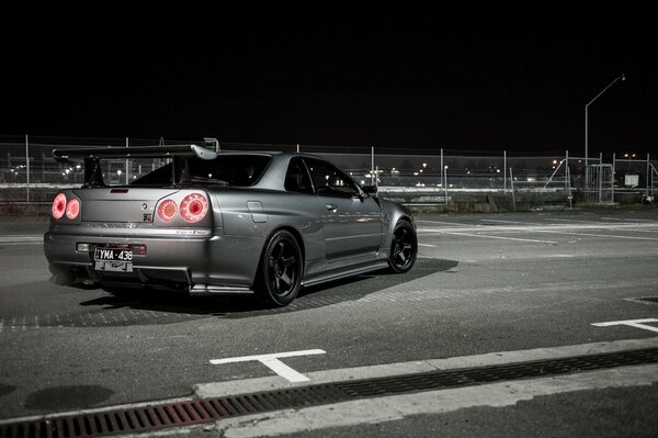 Grey racing car with a spoiler on the trunk