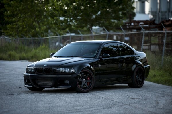 Tinted black bmw at the mesh fence