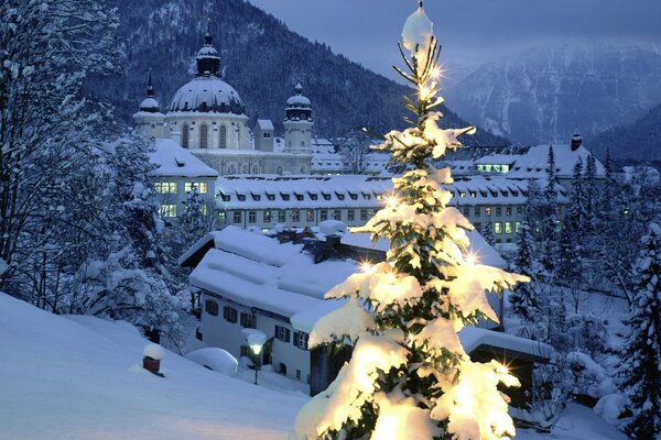 Palacio blanco en la nieve en el fondo de la montaña