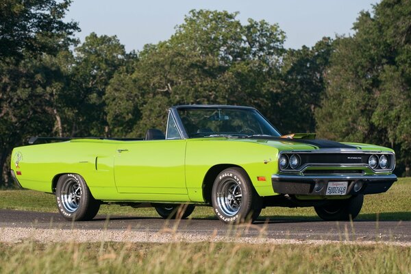 Green convertible on a forest road