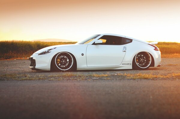 White nissan 370z car on sunset background