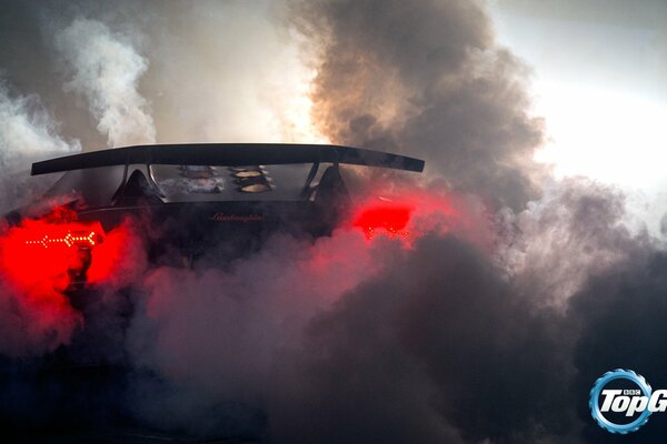 Lamborghini en medio del humo en la carretera