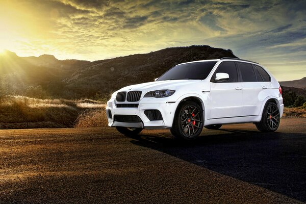 Beautiful white BMW x5 car on sunset background