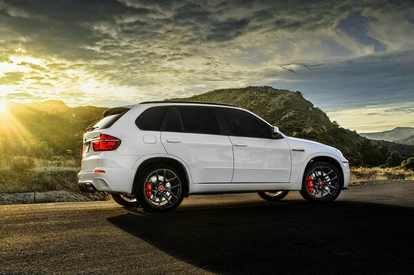 Tuning blanc bmw x5m au coucher du soleil