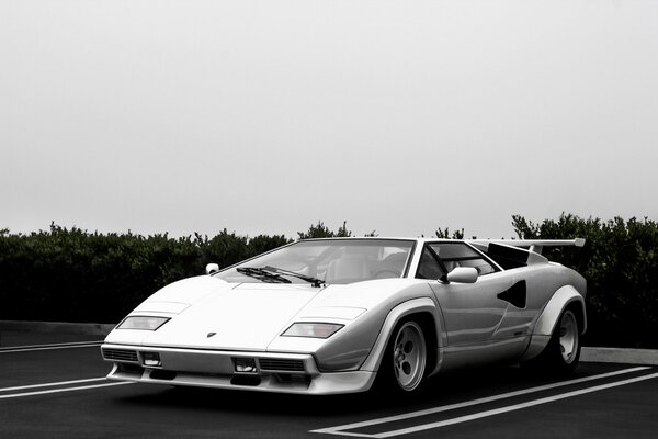 Supercar bianca e parcheggio sotto le nuvole