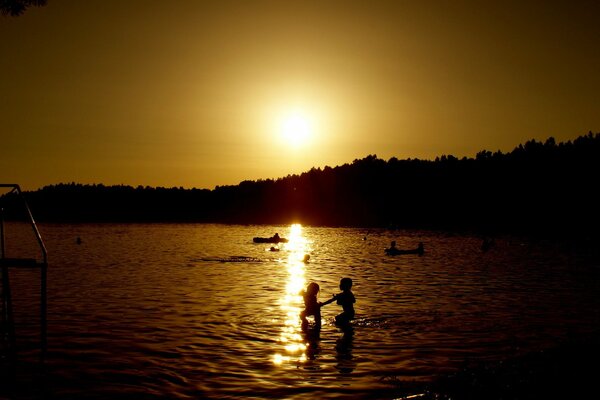 People bathe in the sunset background