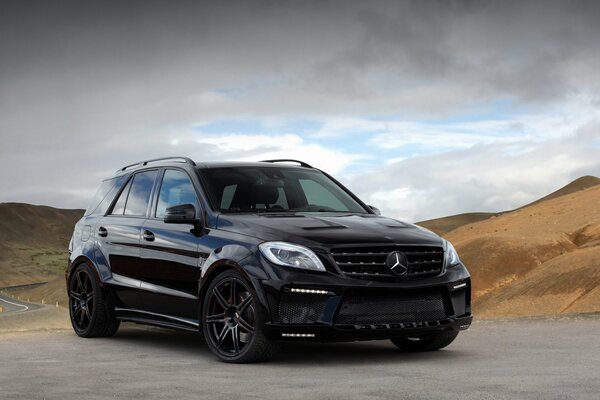 A picture of a standing mercedes ml63 amg topcar car on the background of mountains