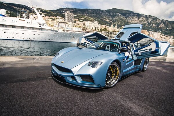 Blue car with open doors on the background of a yacht