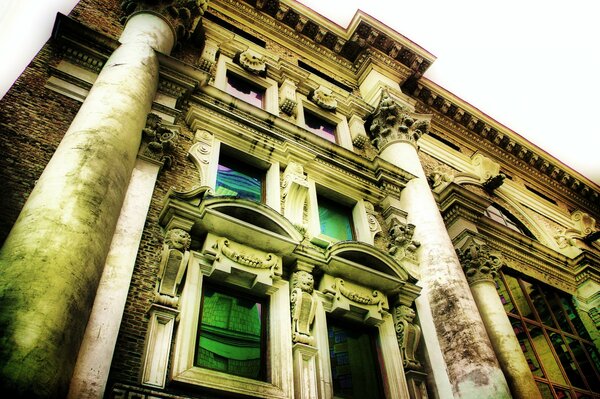 The facade of an old house with green windows