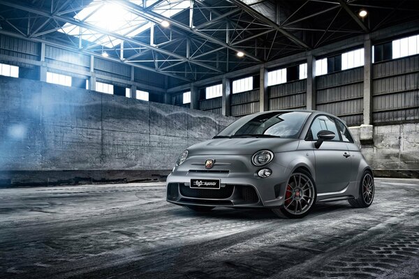 A small gray fiat in the hangar