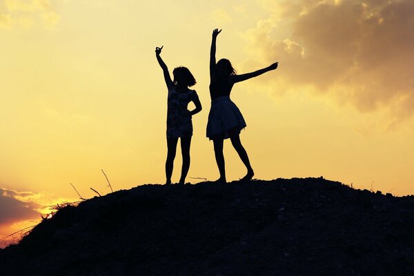 Sagome di due ragazze al tramonto