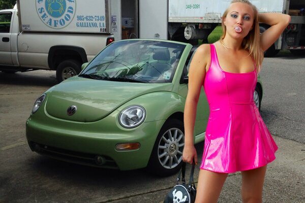 Ragazza bionda circa verde volkswagen Beetle