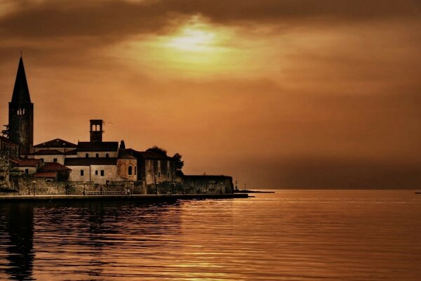 The tower on the shore against the sunset