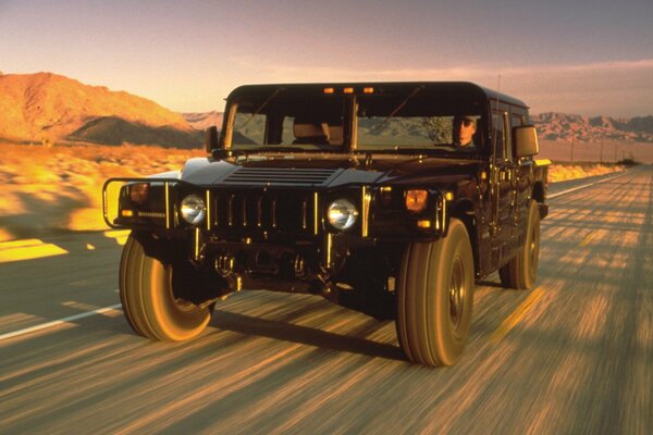 Black hummer SUV on the desert road