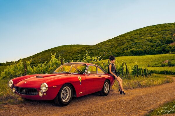 Ragazza situata sulla natura vicino all automobile rossa