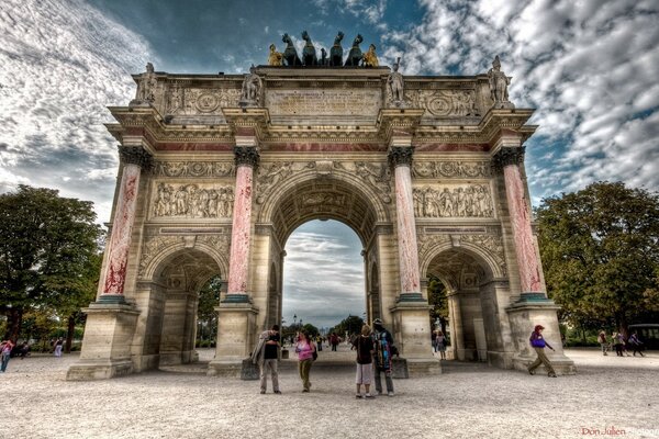 Tourists pass through the arch