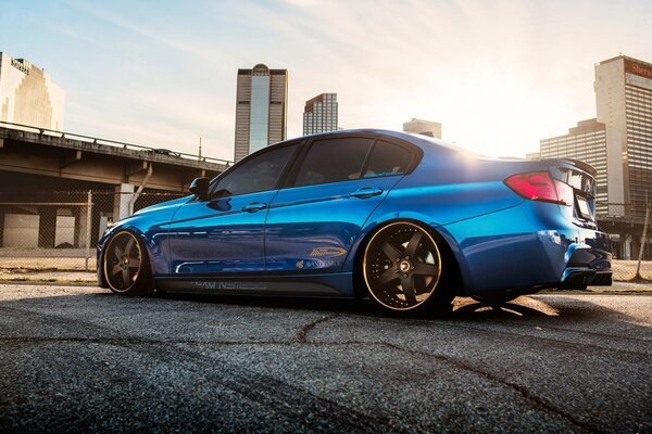 Blue car, sun, glass houses, bridge