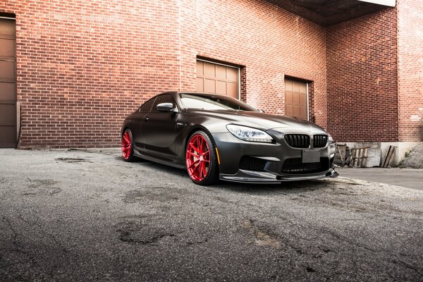 Un BMW coupé negro contra un edificio de ladrillo rojo