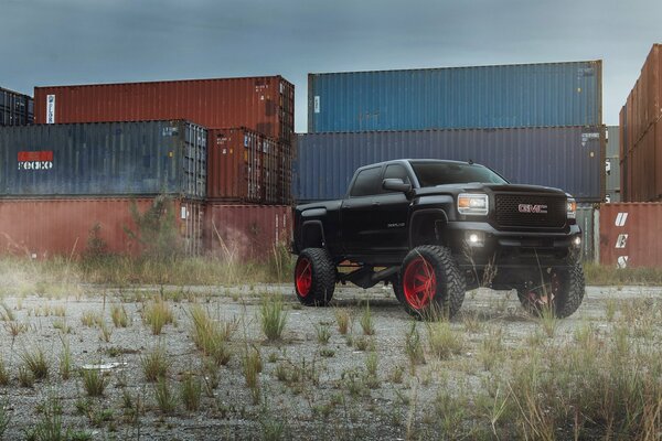 Pickup negro con Tuning en el fondo de los contenedores