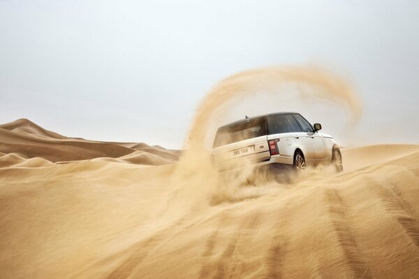 SUV blanco en la deriva en la arena