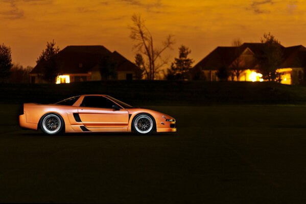 An orange Honda stands at the house of the chairman of the SNT