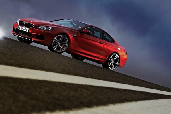 Rojo BMW Coupe en la vista lateral de la carretera