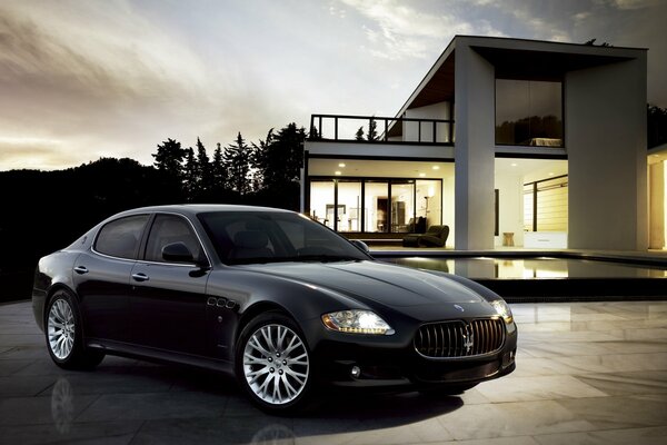 A beautiful life. Black maserate on the background of the house