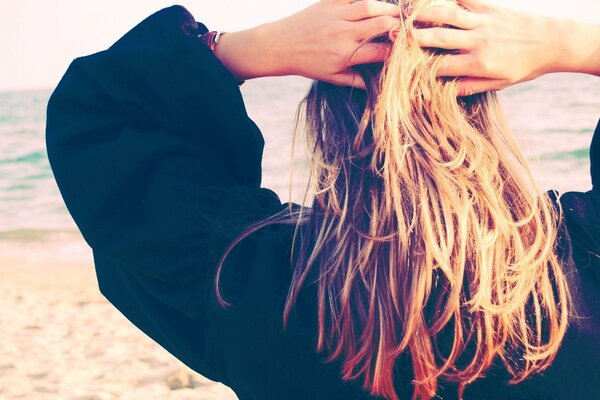 Blonde on a sandy beach from the back