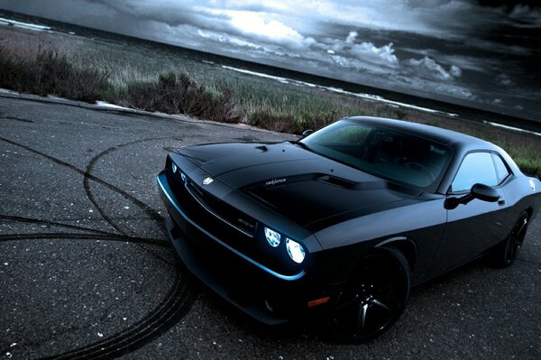 Black handsome dodge challenger after drifting on the road