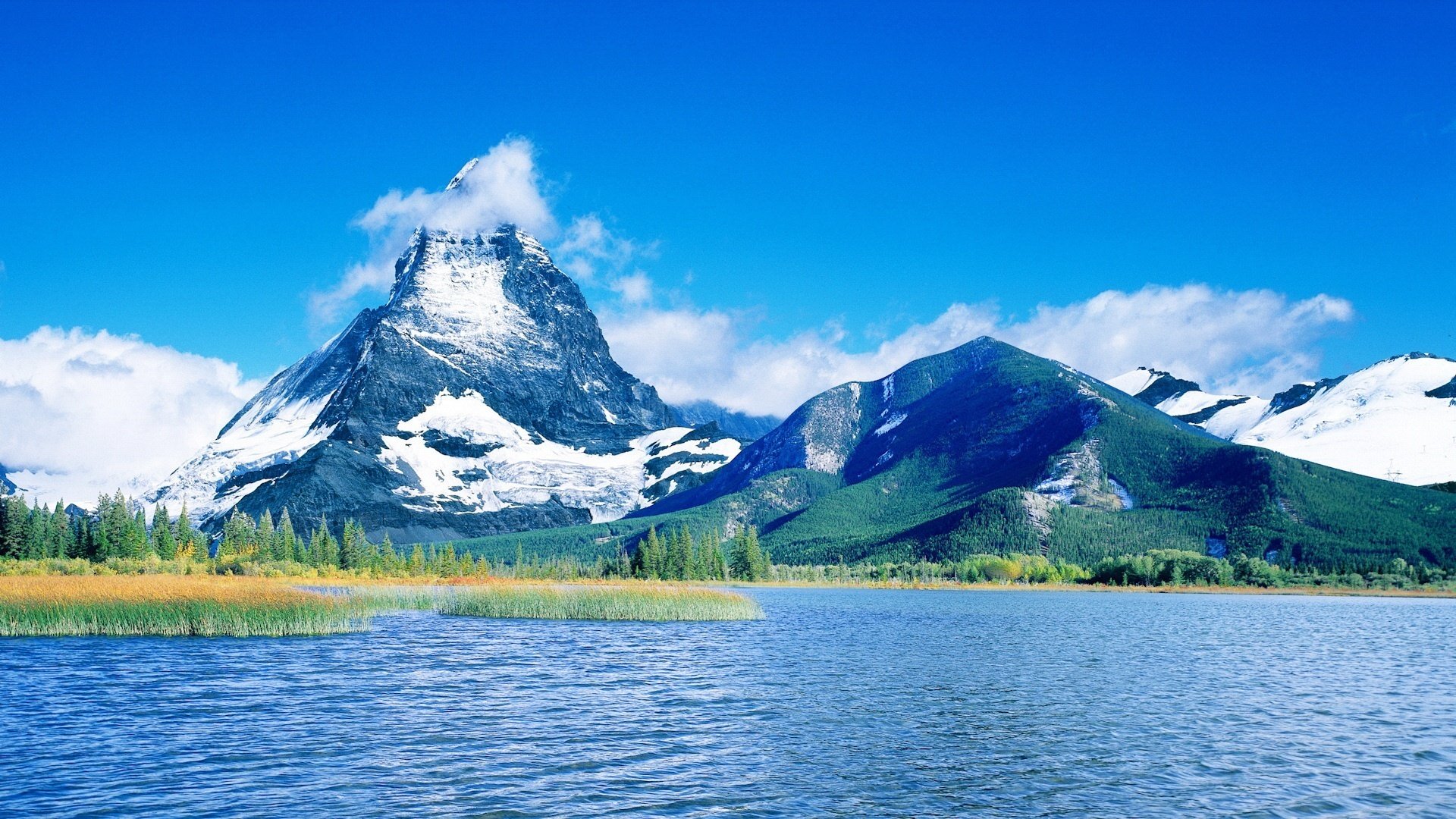 montagnes neige sur le dessus eau bleue eau ciel lac ciel bleu nuages forêt