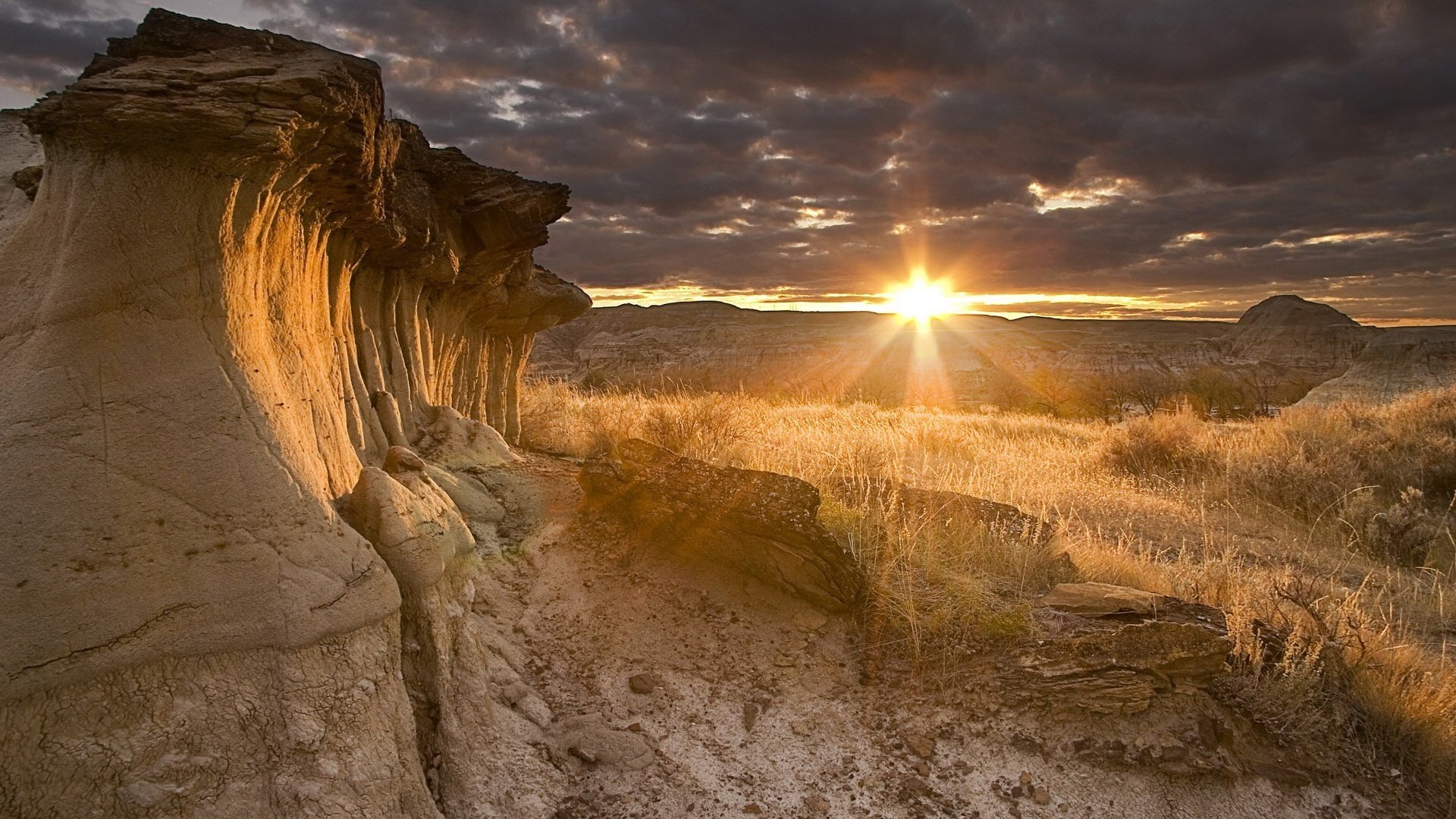 the star called the sun sand rocks of the mountains dry grass sunset landscape cloud