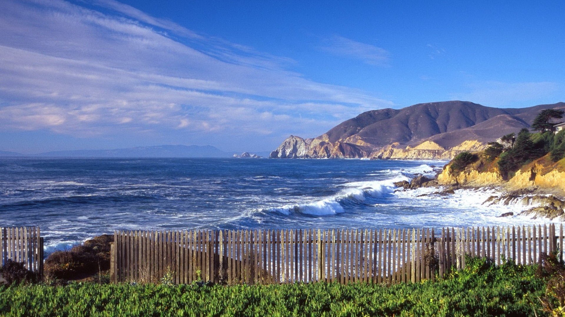 petite clôture bord de mer herbe eau ciel montagnes surf clôture horizon vagues paysage nature verdure végétation pierres