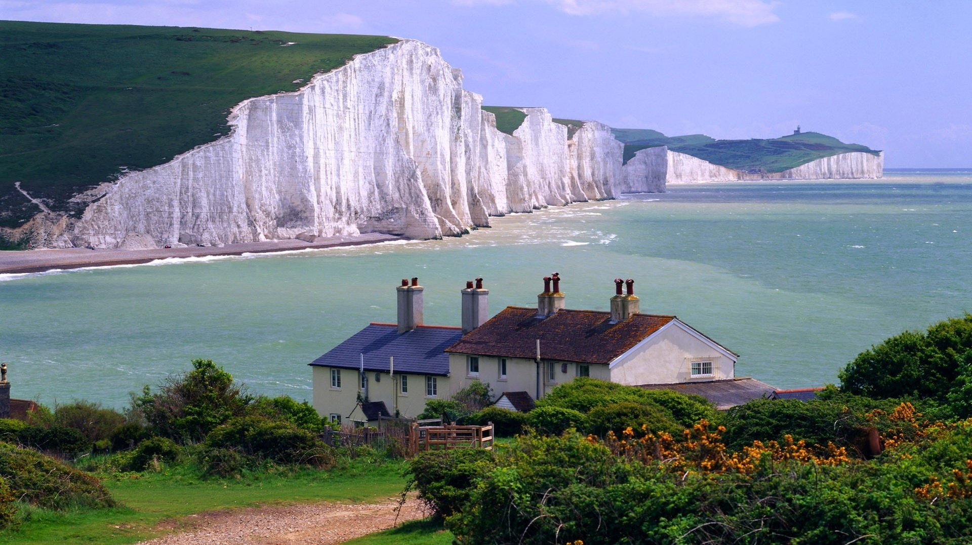 collines dans l herbe roches blanches du sol fleurs maisons maisons roches maison paysage nature paysage relief verdure mer côte surf baie baie toits