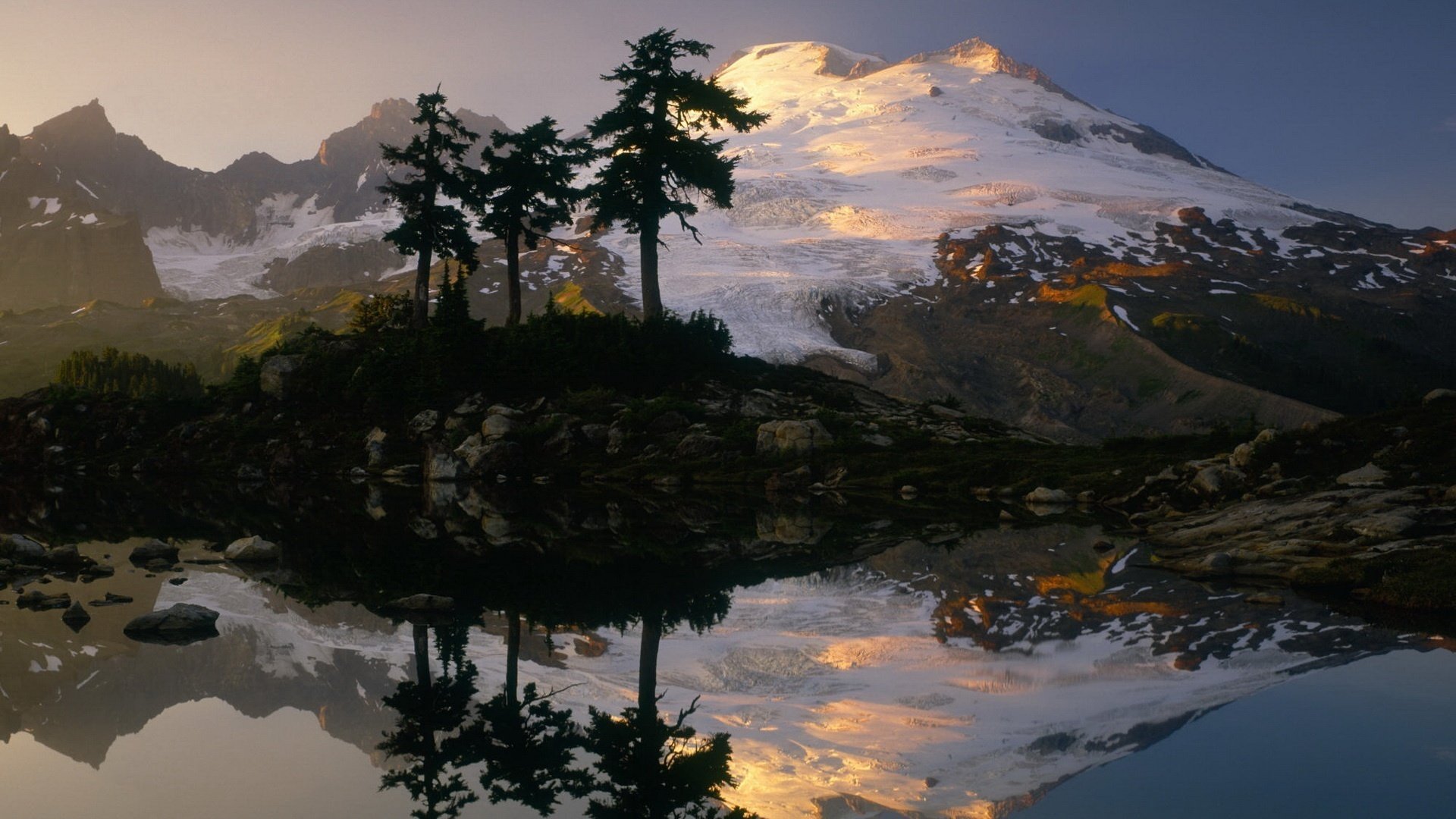 lago specchio montagne nella neve tre alberi alberi di natale montagne acqua sera riflessione superficie liscia natura paesaggio paesaggio pietre