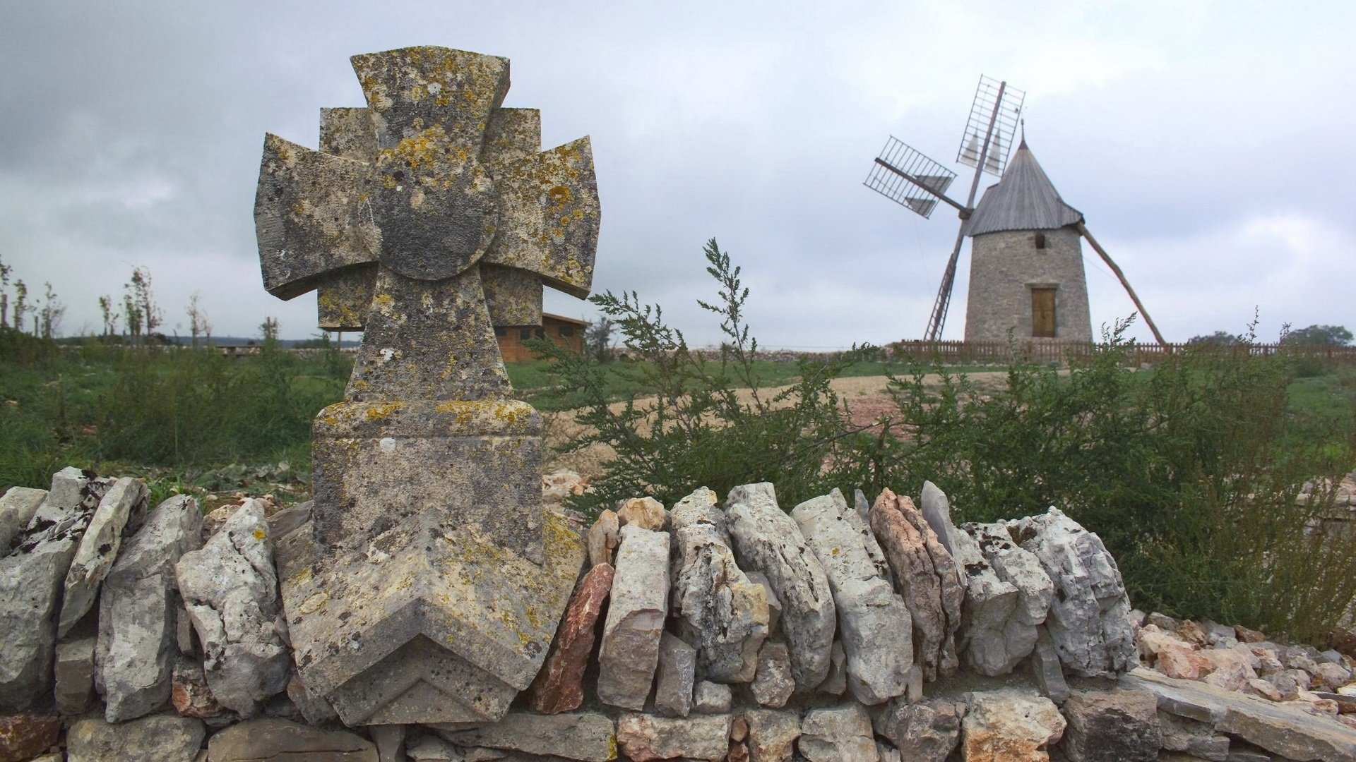 valla de piedra molino campo nubes nubes arbustos vegetación molino de viento