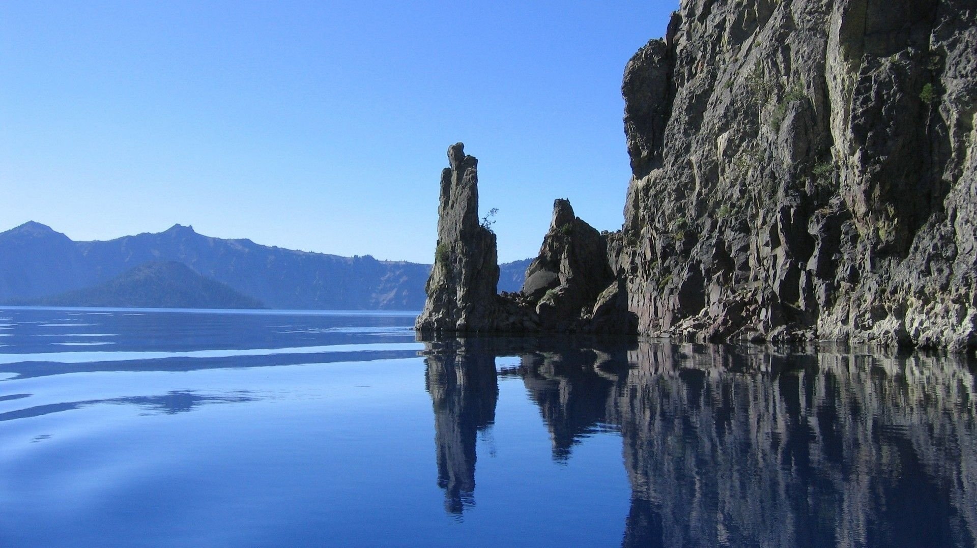 rocks cliff sea water water surface mountains rocks view landscape nature sky